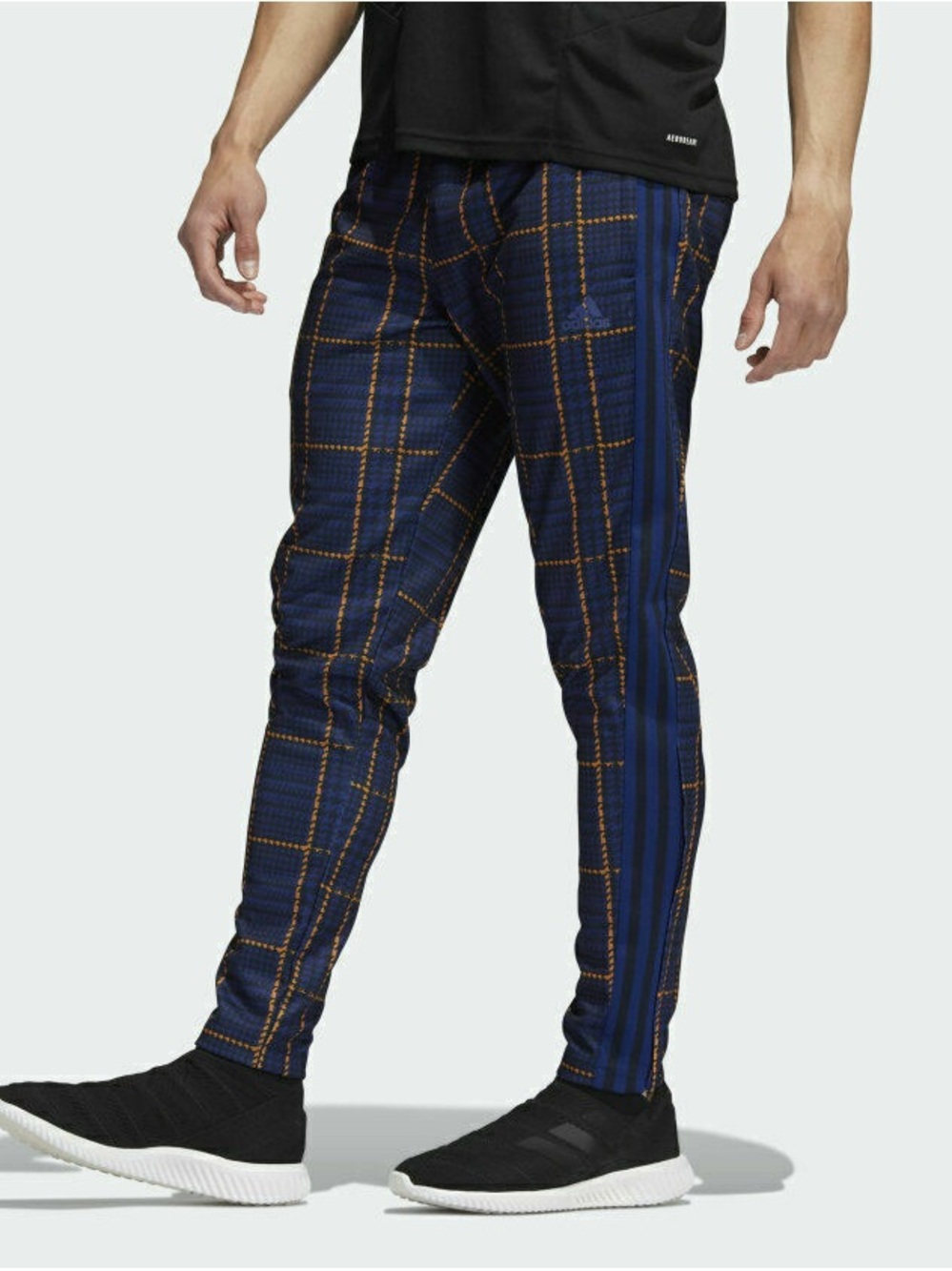 Adidas Tiro Tartan Plaid pants in a navy blue and orange plaid pattern.